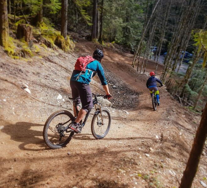 Two mountain bikers are riding their bikes through the corners on the Half Nelson trail in Squamish