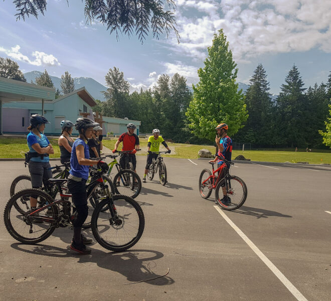 A group of riders listening to their instructor during a Foundations Green mountain bike clinic