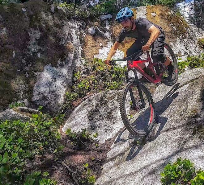 Riding a mountain bike down the double-black rated exit of the trail Gouranga in Squamish