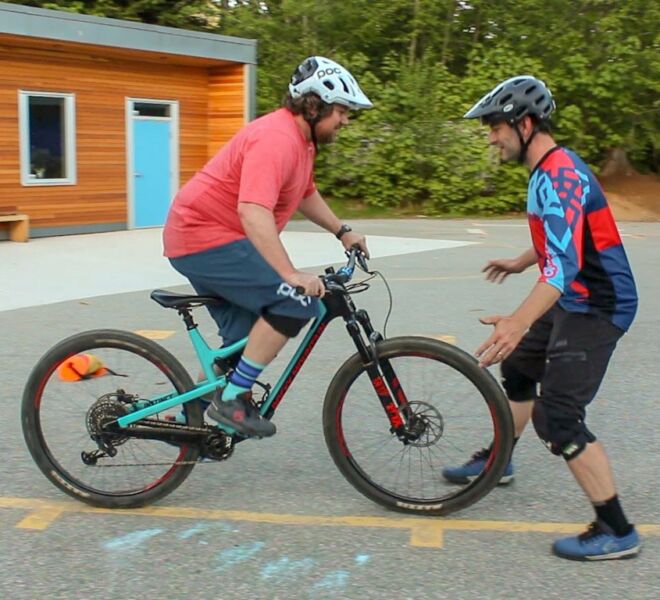 A rider being challenged to balance during a mountain bike skill drill