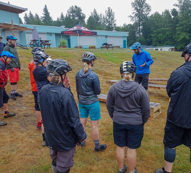 A group getting ready to ride their bikes off of our controlled drops progression area