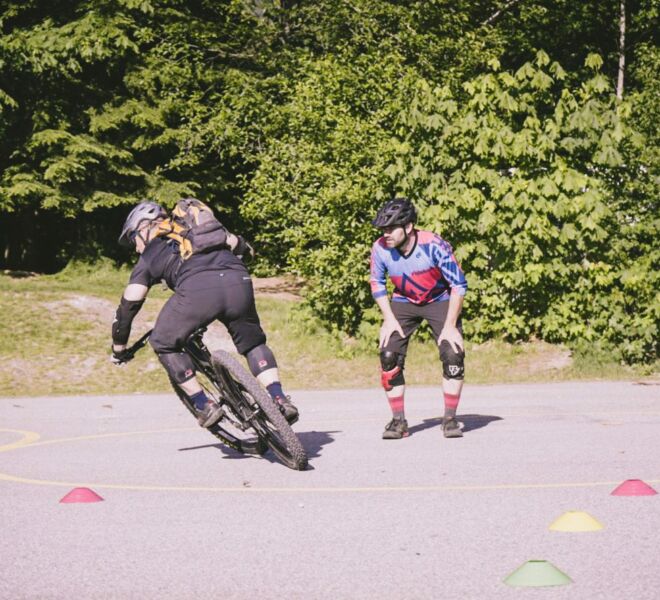 A mountain biker practicing their cornering technique in a controlled environment on pavement to refine their skills safely