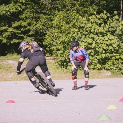 A mountain biker practicing their cornering technique in a controlled environment on pavement to refine their skills safely