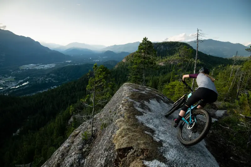 Mountain biker overlooking a scenic valley at dusk.