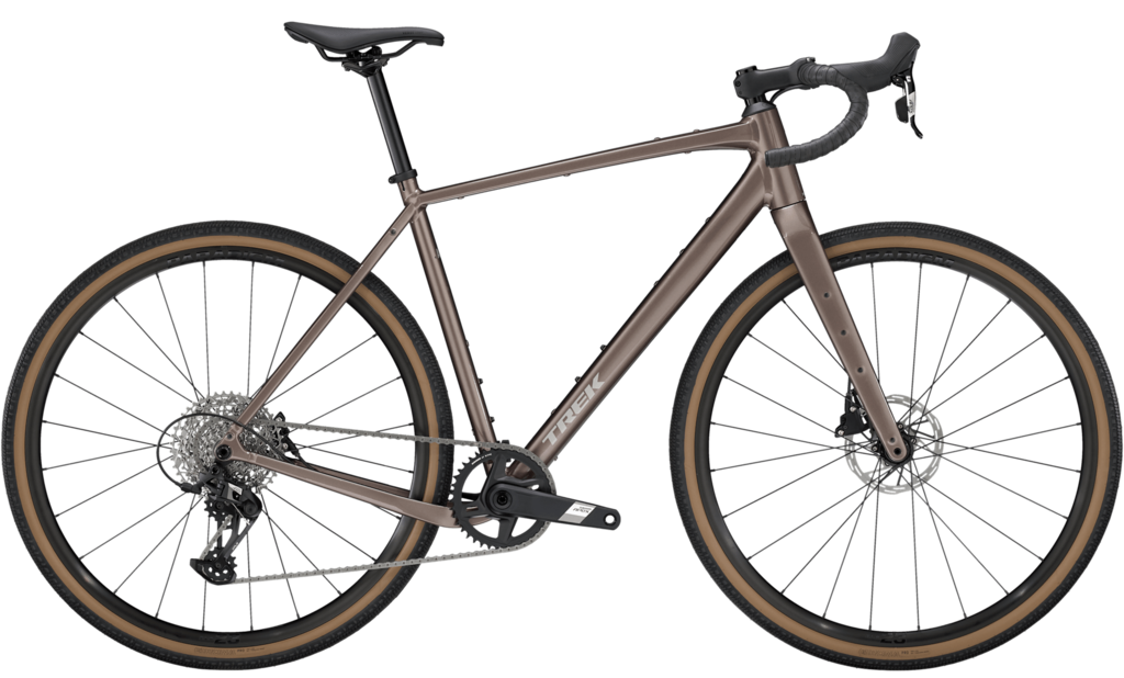 A brown gravel bike with drop handlebars, disc brakes, and tan wall tires is shown in a side profile on a white background.